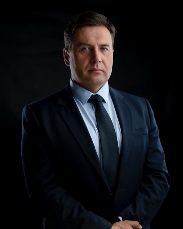 Mężczyzna w granatowym garniturze i krawacie, zdjęcie biznesowe w studiu na ciemnym tle, studio w Katowicach