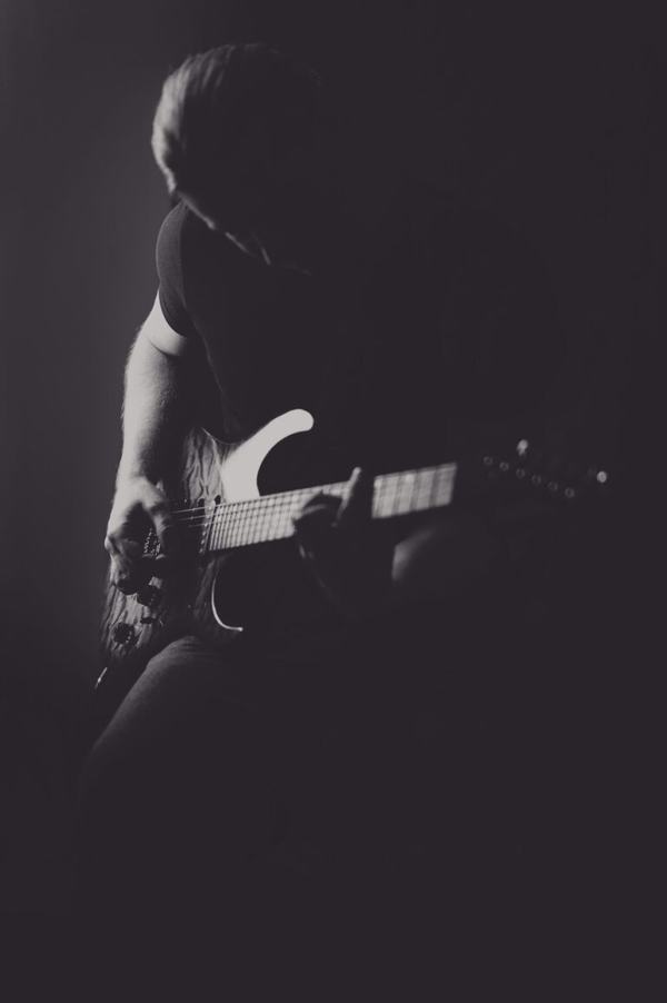 Portret artystyczny: gitarzysta w półmroku