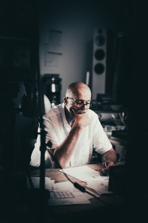 Portret artystyczny: mężczyzna w studiu przy biurku z kolumnami, sepia
