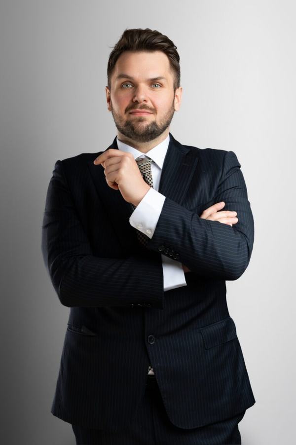 Portret biznesowy: mężczyzna w garniturze z dłonią przy brodzie