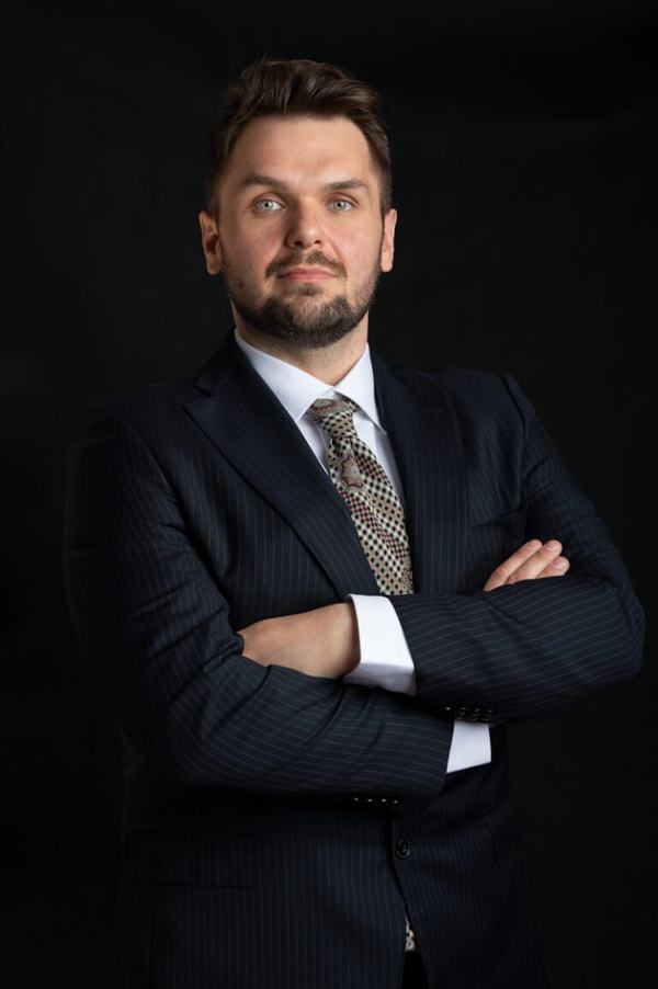 Portret biznesowy: mężczyzna w garniturze w prążki z rękami skrzyżowanymi
