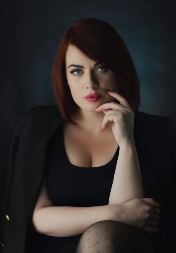Portret wizerunkowy: kobieta z rudym bobem, dłoń przy brodzie